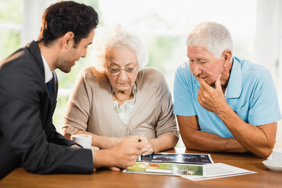 Businessman showing sheets to senior couple at home