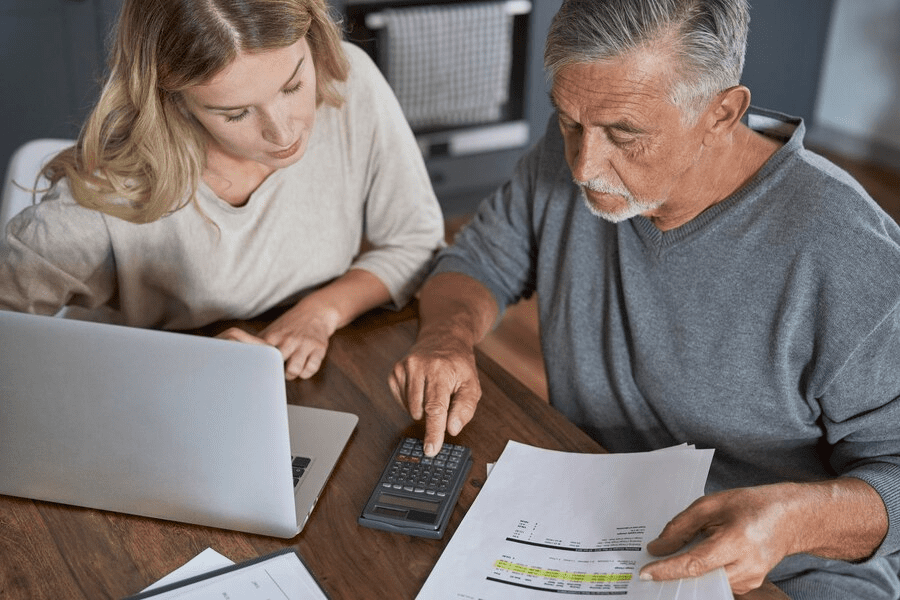 Senior man with adult daughter counting home finance